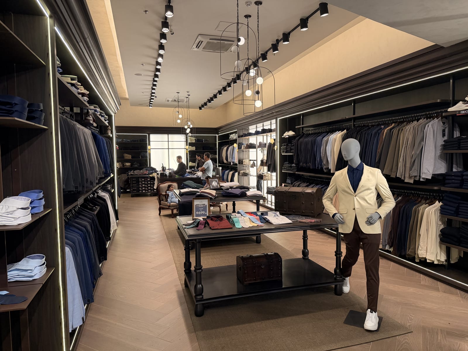Loja Executive em shopping, fachada iluminada e interior com marcenaria e iluminação de destaque