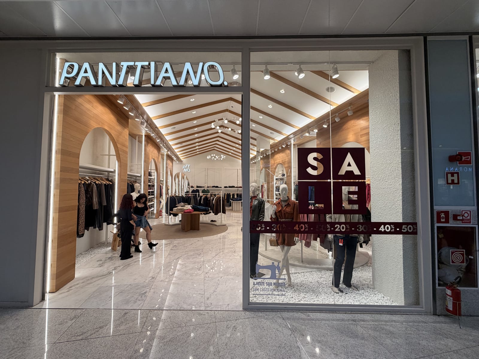 Loja Panttiano em shopping, interior com forro em madeira, arcos e piso em mármore